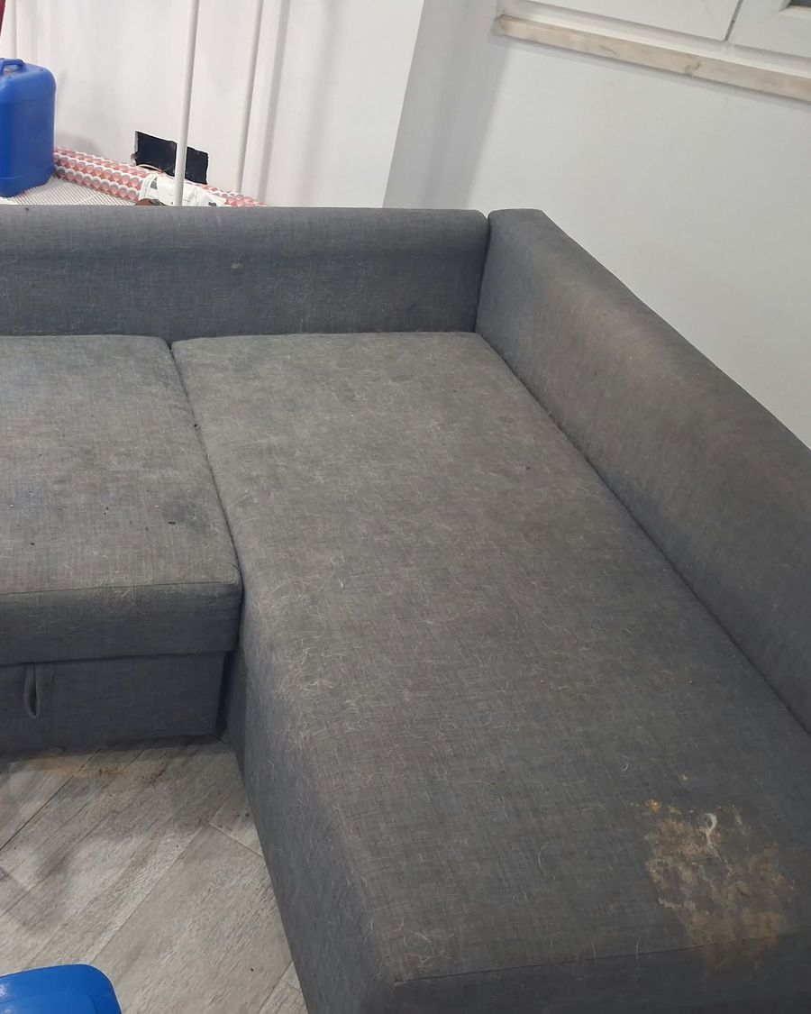 Chaise de sofá cinzento-escuro com uma nódoa grande no assento